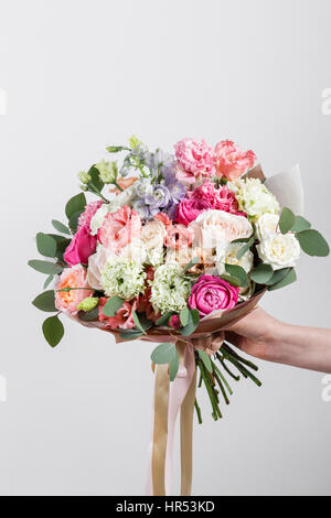 Riche bouquet de fleurs roses et rose eustoma, vert feuille dans la main bouquet frais du printemps. Arrière-plan de l'été. Banque D'Images