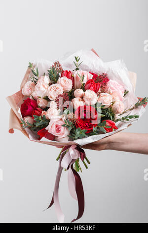 Riche bouquet de fleurs roses et rose eustoma, vert feuille dans la main bouquet frais du printemps. Arrière-plan de l'été. Banque D'Images