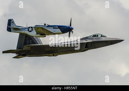 Vol du patrimoine de l'US Air Force du chasseur furtif F22 Raptor et de la Mustang nord-américaine P51 au Flying Legends Air Show à l'IWM Duxford Banque D'Images