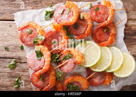 Gambas grillées avec du chorizo et des herbes sur les brochettes, gros plan sur la table. Vue du dessus horizontale Banque D'Images