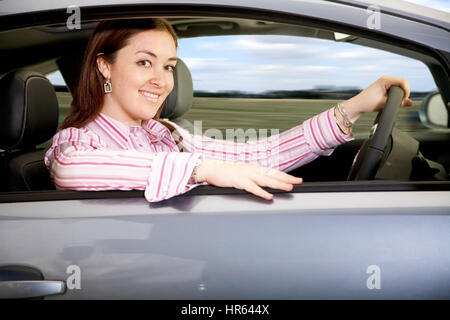 Business Woman smiling et conduire une voiture nouvelle Banque D'Images