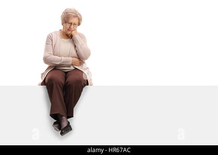 Pensive femme âgée assise sur un panneau isolé sur fond blanc Banque D'Images