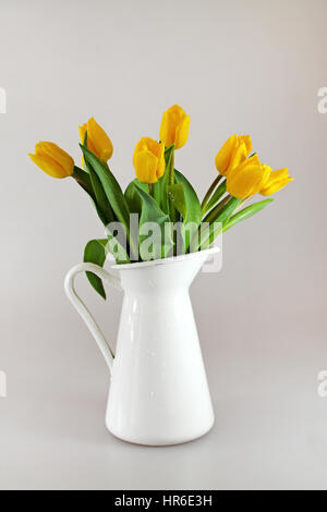Bouquet de tulipes jaunes dans la verseuse avec des oeufs de pâques. Banque D'Images