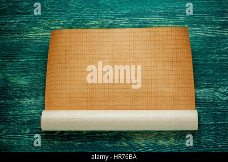 Rouleaux de plan vide sur planche de bois vert. Vue d'en haut. Banque D'Images