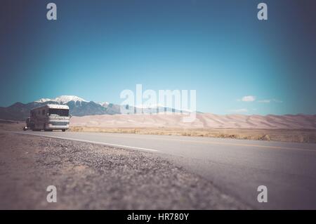 Véhicule de loisirs avec un Œillet sur le Colorado Road près de Great Sand Dunes. Voyageant en classe un RV Camping en Amérique. Banque D'Images