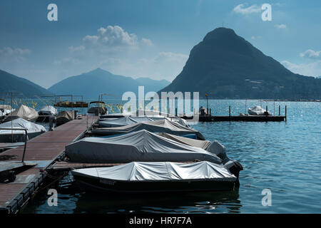 Bateaux à moteur amarré sur le lac de Lugano avec le Monte San Salvatore à l'arrière-plan Banque D'Images