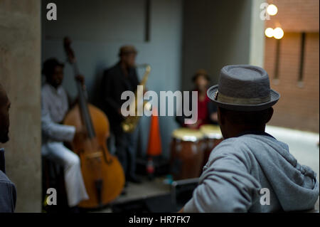 Un spectateur regarde les musiciens de jazz effectuer au centre-ville de Johannesburg, Afrique du Sud. Banque D'Images