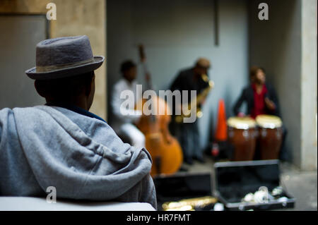 Un spectateur regarde les musiciens de jazz effectuer au centre-ville de Johannesburg, Afrique du Sud. Banque D'Images