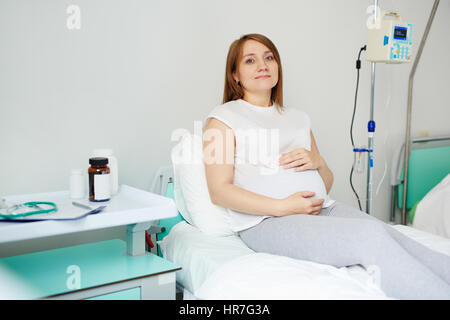 Portrait de femme enceinte pacifiques reposant sur le lit d'hôpital avant dernière échographie Banque D'Images
