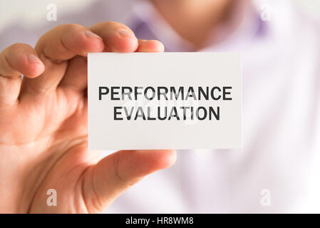 Gros plan sur businessman holding une carte avec un message d'ÉVALUATION DU RENDEMENT, concept d'entreprise image avec arrière-plan flou et vintage tone Banque D'Images