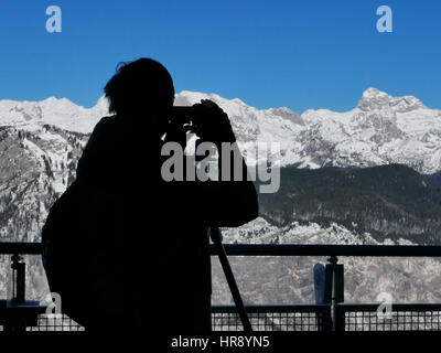 Silhouette de femme photographe de paysage de capturer une vue imprenable sur les montagnes enneigées Banque D'Images