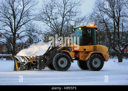 SALO, FINLANDE - le 24 février 2017 : opérateur inconnu enlève la neige avec Volvo L35B Chargeur sur roues compact équipé d'un chasse-neige sur une soirée d'hiver dans la Banque D'Images