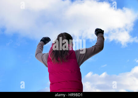 La jeune femme mains sous ciel nuageux. Banque D'Images