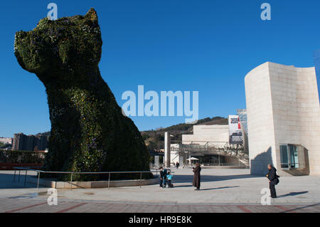 Espagne : la sculpture fleur chiot, créé en 1992 par Jeff Koons à l'entrée du Musée Guggenheim Bilbao, et vue sur les toits de la ville Banque D'Images