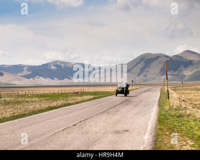 L'Italie, Castelluccio di Norcia - 25 Avril 2015 : motocyclistes sur la route de grand plan de Monti Sibillini. Les motocyclistes dans un véhicule d'un side-car comme salute Banque D'Images