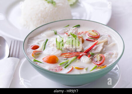 Thai Food, Tom Kha Gai, soupe de poulet à la crème de coco en blanc avec du riz vapeur à côté. Banque D'Images