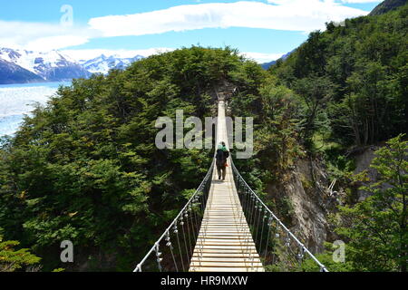 Backpacker non identifiés traversant un pont suspendu de Torres de Paine, Chili Banque D'Images