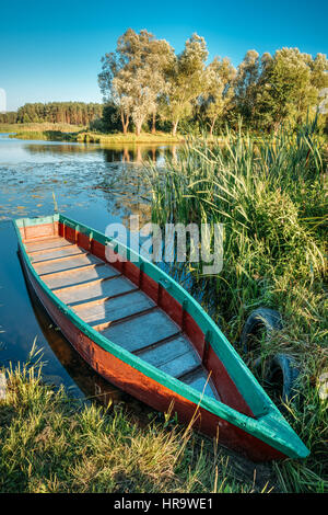 Lac ou rivière et Vieux Bois Aviron Bleu Bateau de pêche au belle journée ensoleillée d'été ou en soirée. Banque D'Images