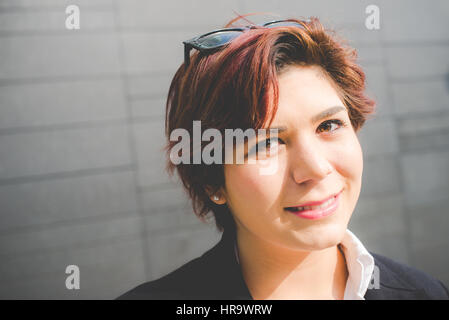 Young woman smiling business authentique sur fond de mur moderne Banque D'Images