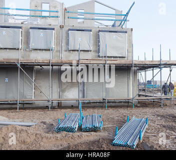 Ossature en béton de maison nouvellement construite avec des échafaudages et les tuyaux en métal Banque D'Images