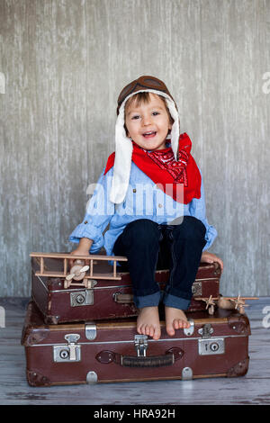 Gentil petit bébé garçon, jouant avec des voitures et des jouets à la maison, heureusement smiling Banque D'Images