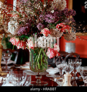 Un vase de fleurs sur une table à manger. Banque D'Images