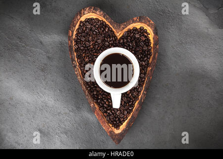 Grains de café dans un bol en forme de coeur Banque D'Images