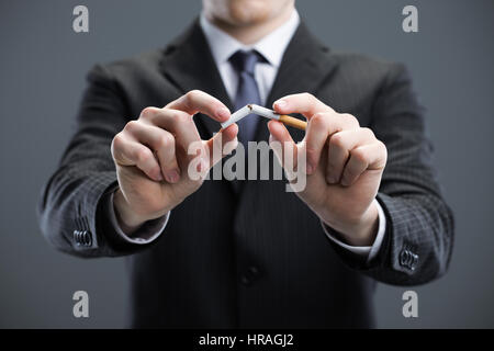 Des mains humaines breaking cigarette Banque D'Images