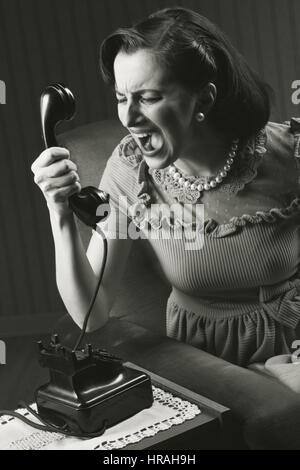 Femme en colère crier au téléphone rétro, style 1950 Banque D'Images