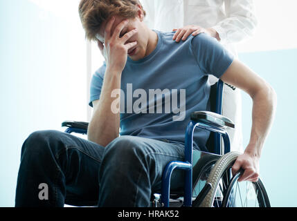Femme médecin triste consolation man sitting in wheelchair Banque D'Images