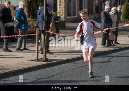 Le Grove, Ilkley, West Yorkshire, Royaume-Uni. 28 Février, 2017. Les jeunes concurrents (garçon) est en cours d'exécution et de prendre part à l'assemblée annuelle, traditionnelle Course de crêpes rotatif Ilkley. Crédit : Ian Lamond/Alamy Live News Banque D'Images