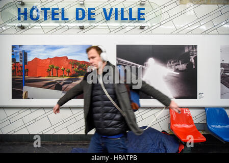 Paris, France. 28 Février, 2017. Un passager imite le figure dans un magnum a montré la photo derrière lui à l'Hôtel de Ville de Paris la station de métro ligne 1 à Paris, France, le 28 février 2017. À l'occasion du 70e anniversaire de Magnum Photos, la RATP (opérateur autonome de Transports Parisiens) présente un total de 174 magnum photos dans ses 11 stations dans Paris, du 28 février au 30 juin. Crédit : Chen Yichen/Xinhua/Alamy Live News Banque D'Images