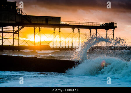 Aberystwyth, Pays de Galles, Royaume-Uni. 28 Février, 2017. Météo France : le coucher du soleil et des vagues et de la mer une jetée à la fin d'un très froid et très venteux Mardi Gras à Aberystwyth, sur la côte ouest du pays de Galles Crédit photo : Keith morris/Alamy Live News Banque D'Images