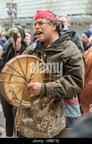 Vancouver, Canada. 28 Février, 2017. Membre de la bande des Premières nations Musqueam, chantant une chanson d'origine à l'ouverture de l'hôtel Trump International, qui a attiré quelques centaines de manifestants anti-Trump mécontents de l'Atout 'nom' étant associée à la ville de Vancouver. Trump International Hotel. Credit : Gerry Rousseau/Alamy Live News Banque D'Images