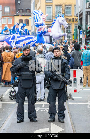 Défilé de carnaval allemand à Düsseldorf, les officiers de police fixent la parade, bloquant les routes avec les camions, contre des attaques terroristes avec des véhicules équipés, Banque D'Images