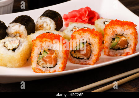 Ensemble rouleau de sushi différents en Californie, avec le saumon et les crevettes tempura sur une plaque Banque D'Images