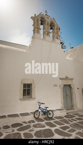 Location appuyé contre le mur au-dessous du clocher en face d'une petite église à Paros, l'une des îles des Cyclades en Grèce Banque D'Images