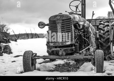 Stationnement du tracteur vintage en jardin et la rouille, noir et blanc Banque D'Images