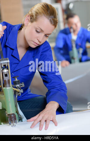 Femme à l'aide de machines à coudre industrielles Banque D'Images