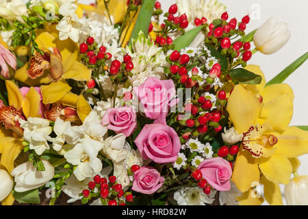 Roses et orchidées. Orchidées et roses corail vinique dans ensemble de différentes fleurs de près. Banque D'Images