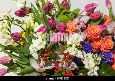 Roses et orchidées. Orchidées et roses corail vinique dans ensemble de différentes fleurs de près. Banque D'Images