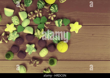Vue de dessus sur un bouquet de bonbons en gelée en forme d'étoiles, de coeurs et Tannis boules sur table en bois Banque D'Images