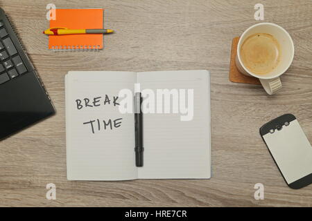 Ordinateur portable ouvert avec un message et une tasse de café sur fond de bois. Vue d'en haut Banque D'Images