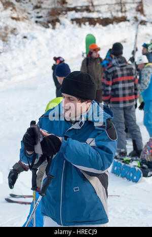 Jeune homme en veste de ski et smartfon Banque D'Images