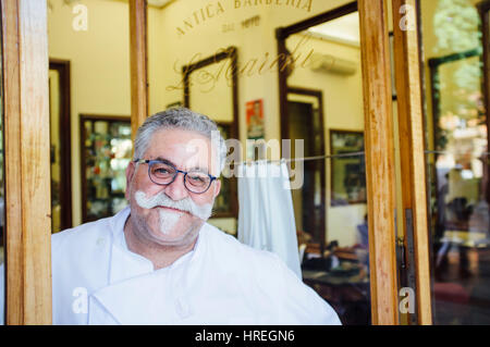 L'homme souriant à l'Italienne Antica Barberia le Marchi, qui est l'un des plus vieux salon de coiffure à Bologne, en Italie. Banque D'Images