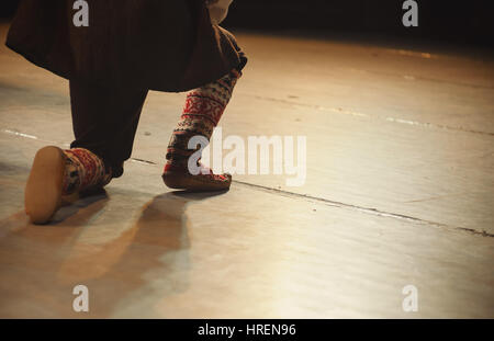 Détails des jambes du danseur, habillé en robe traditionnelle serbe jouant sur scène. Banque D'Images
