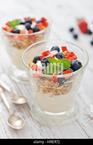 Barres granola avec yogourt et de bleuets et de fraises en verre sur fond de bois Banque D'Images