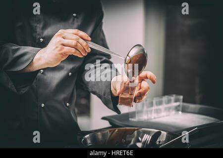 Chef de la préparation de la mousse au chocolat en dessert une cuisine de restaurant Banque D'Images