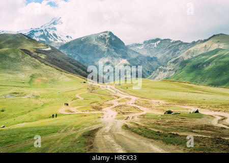 La Géorgie. Broken Road à partir de l'église Sainte trinité Gergeti avec vue sur le mont Kazbek près du village de Gergeti en Géorgie. Banque D'Images