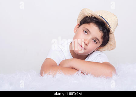 Enfant réfléchie. Penser petit garçon lying on bed Banque D'Images